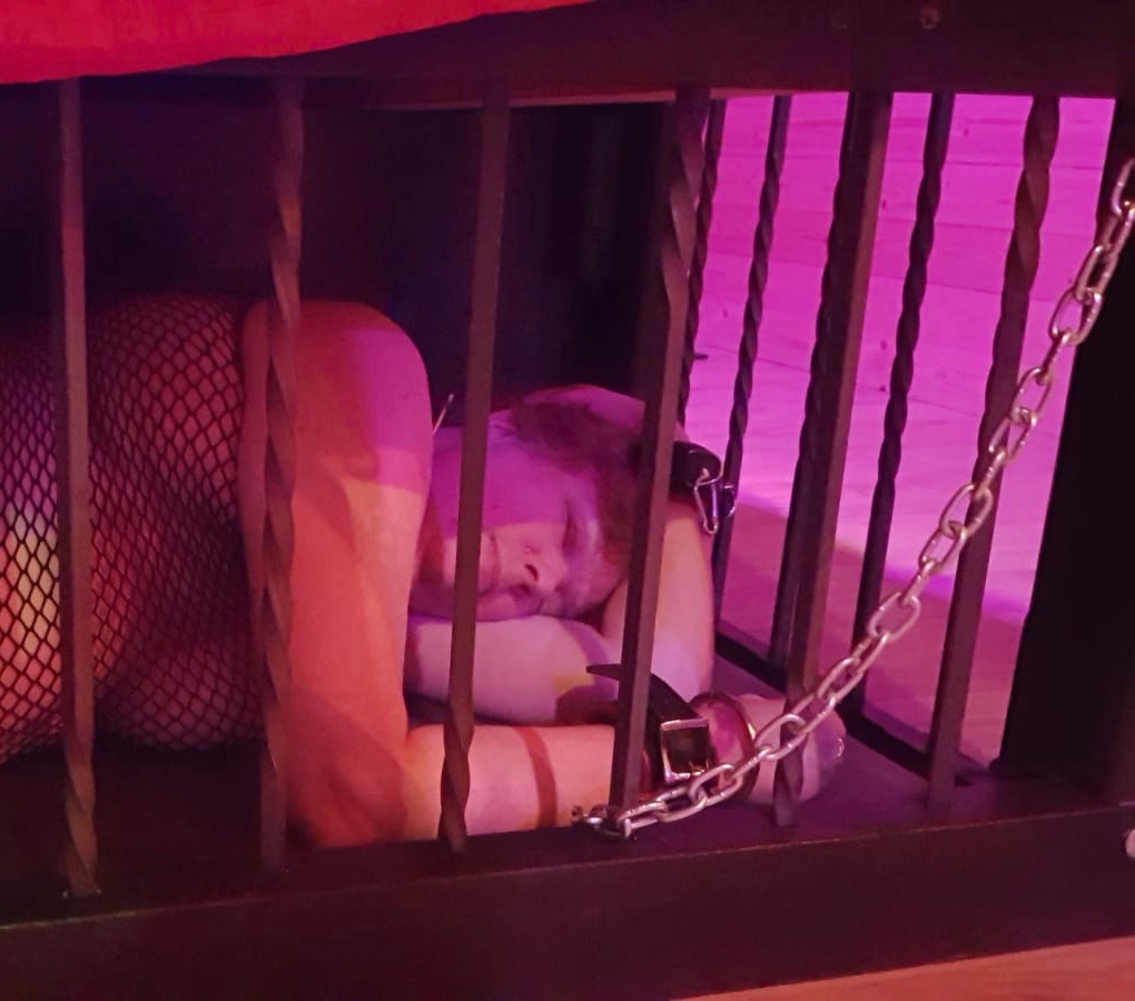 Me lying chained in a cage under the bed st the Stoxx dungeon.