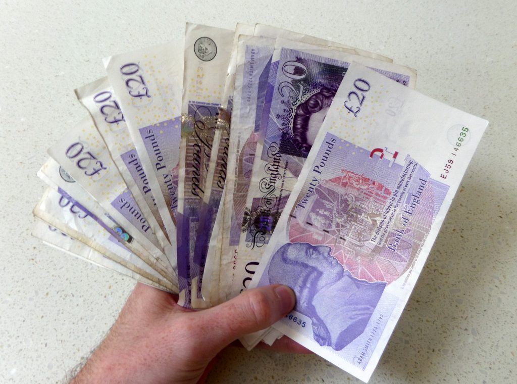 Someone holding several £20 notes