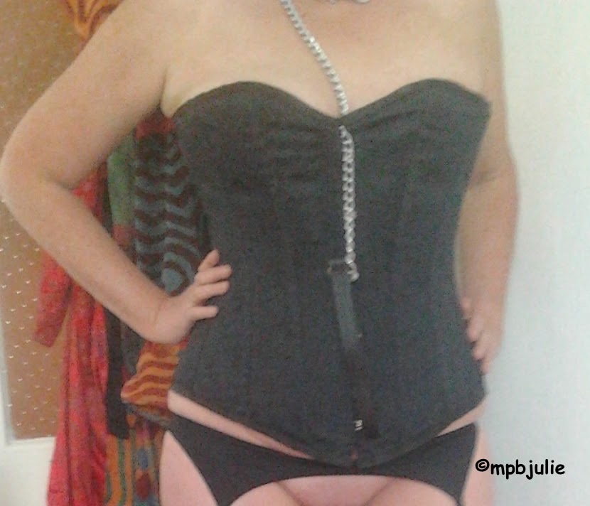 I'm wearing a black corset. Also there is a chain from a dog collar hanging down. I'm wearing suspenders. 