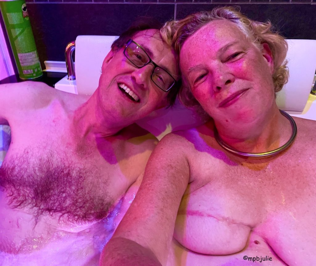 We're in the bath together. You can see our top halves. In the background to the left is a tube of Pringles. The photo is pink, from the lighting but I've enhanced it a little.