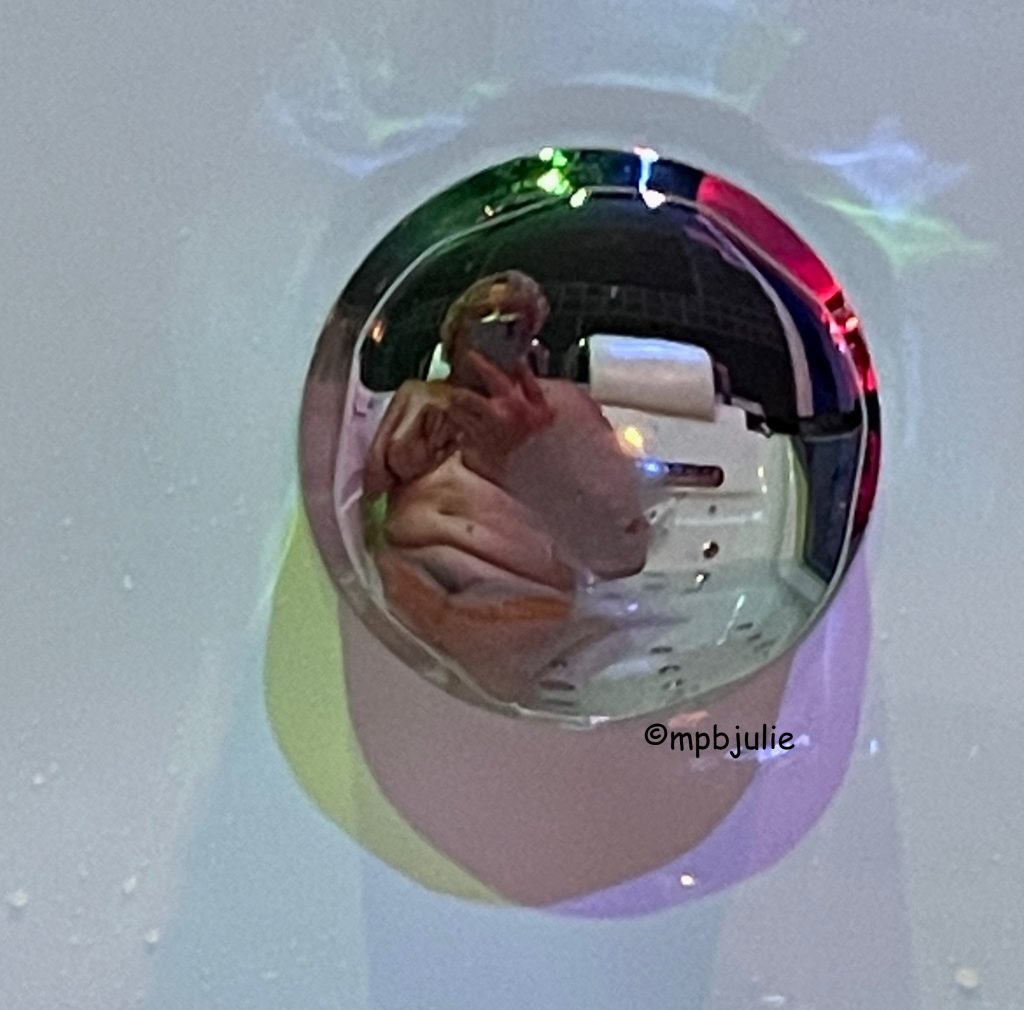 A reflection of me taken in a jacuzzi bath. I'm naked and you can see that the seat next to me is vacant. 