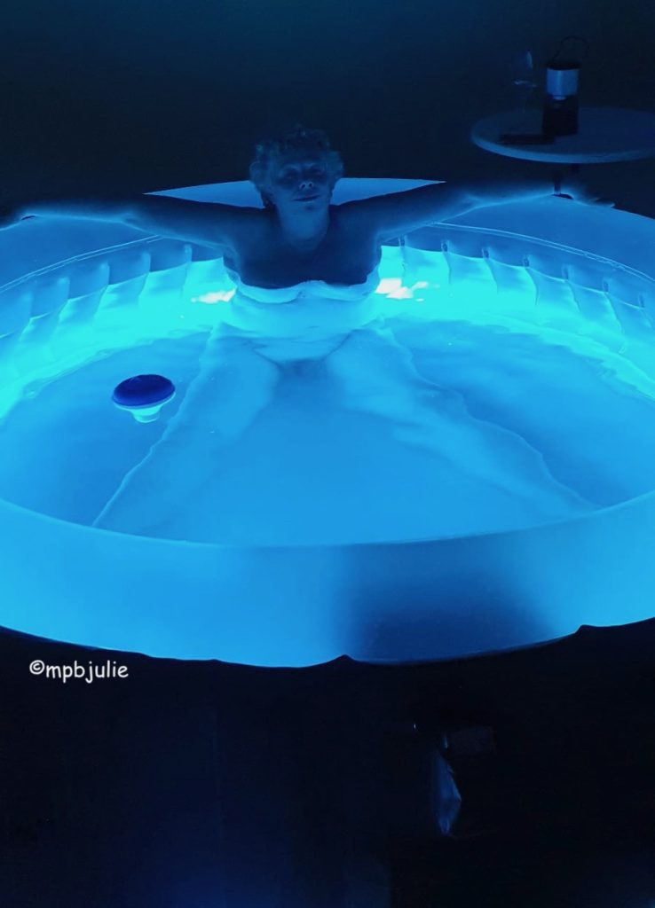 Me in the hot tub. Sitting upright arms stretched around the sides and legs wide. The tub is glowing blue.