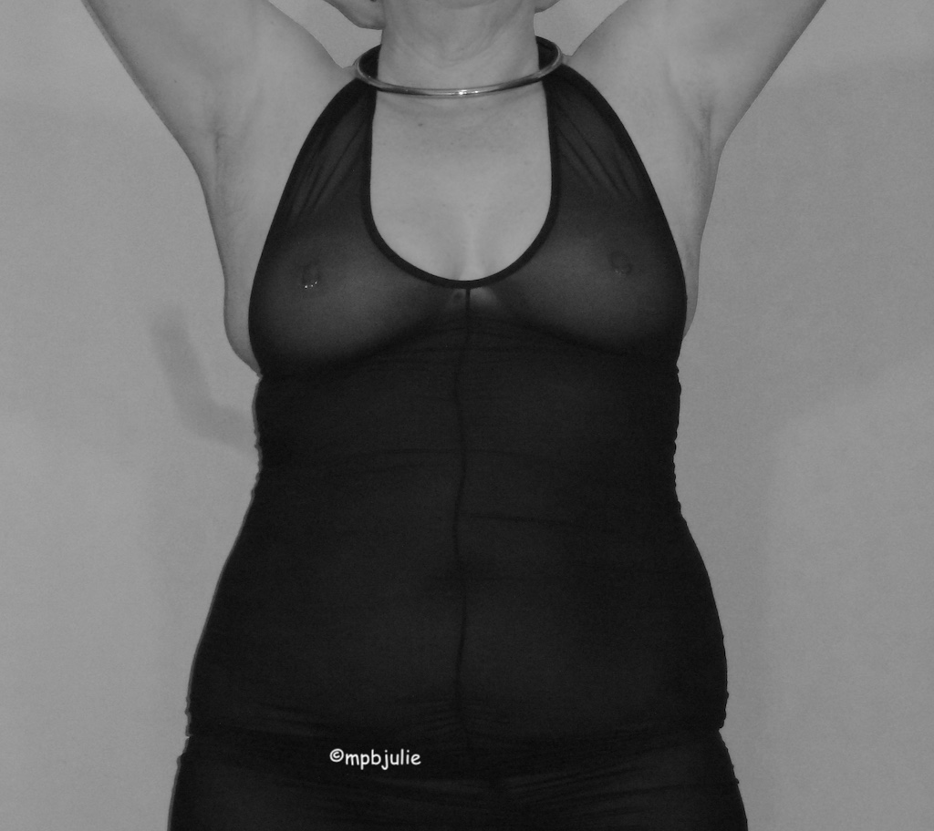 I'm standing back to the wall, arms above my head. I'm wearing a thin halter neck dress that is see through. My nipples show through along with jewellery  