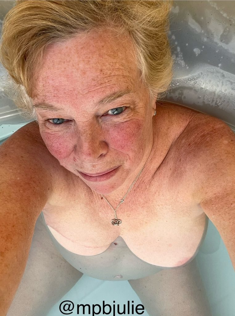 A hot tub selfie, from above. Hair, face, shoulders and bobs. No bubbles yet so you can see between my legs