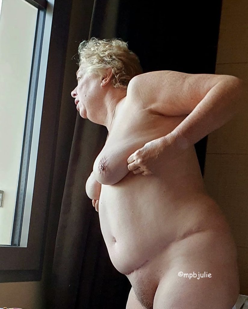 I'm standing naked looking out of the window but you can't see the view. I've just go up in the morning. There are brown curtains behind me