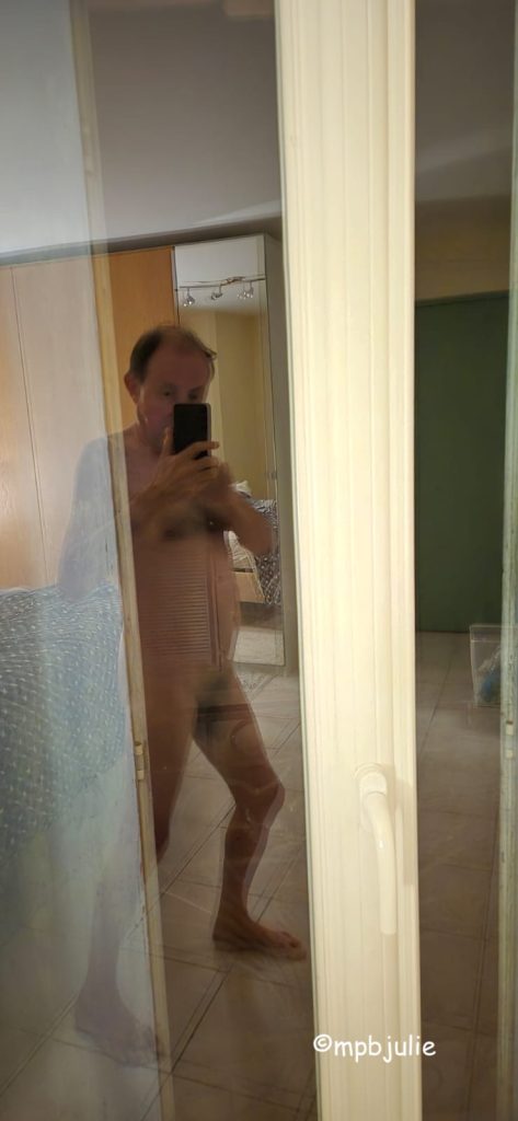 Graeme naked taking a selfie in our bedroom in France. Reflected on the door to our balcony 